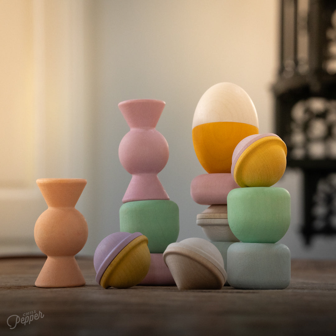 Chill Pepper Treats – Wooden Stacking & Spinning toys - all pieces on a wooden table and a blurred background