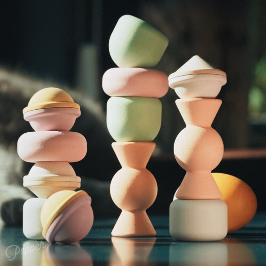 Wooden Chill Pepper Treats stacking and spinning game for ages 3 and up, made from eco-friendly maple wood and non-toxic, water-based paints. The set includes a variety of pastel-colored candy-shaped pieces and a unique Magic Egg for open-ended play. Here you see them stacked in various ways