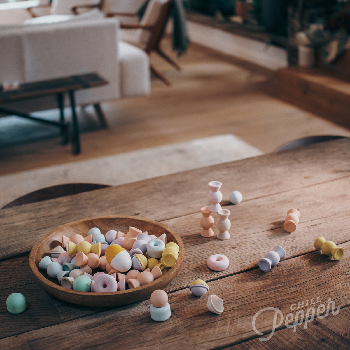 Wooden Chill Pepper Sweets stacking and spinning game for ages 3 and up, made from eco-friendly maple wood and non-toxic, water-based paints. The set includes 27 pastel-colored candy-shaped pieces and 6 gumballs for open-ended play.