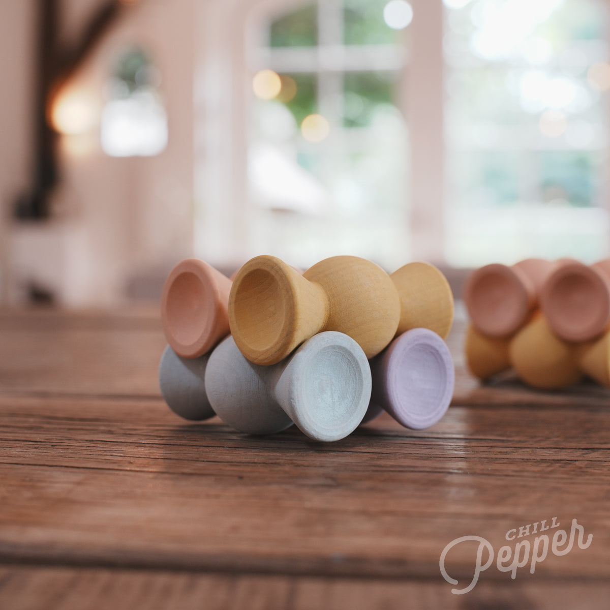 Wooden Chill Pepper Sweets stacking and spinning game for ages 3 and up, made from eco-friendly maple wood and non-toxic, water-based paints. The set includes 27 pastel-colored candy-shaped pieces and 6 gumballs for open-ended play.