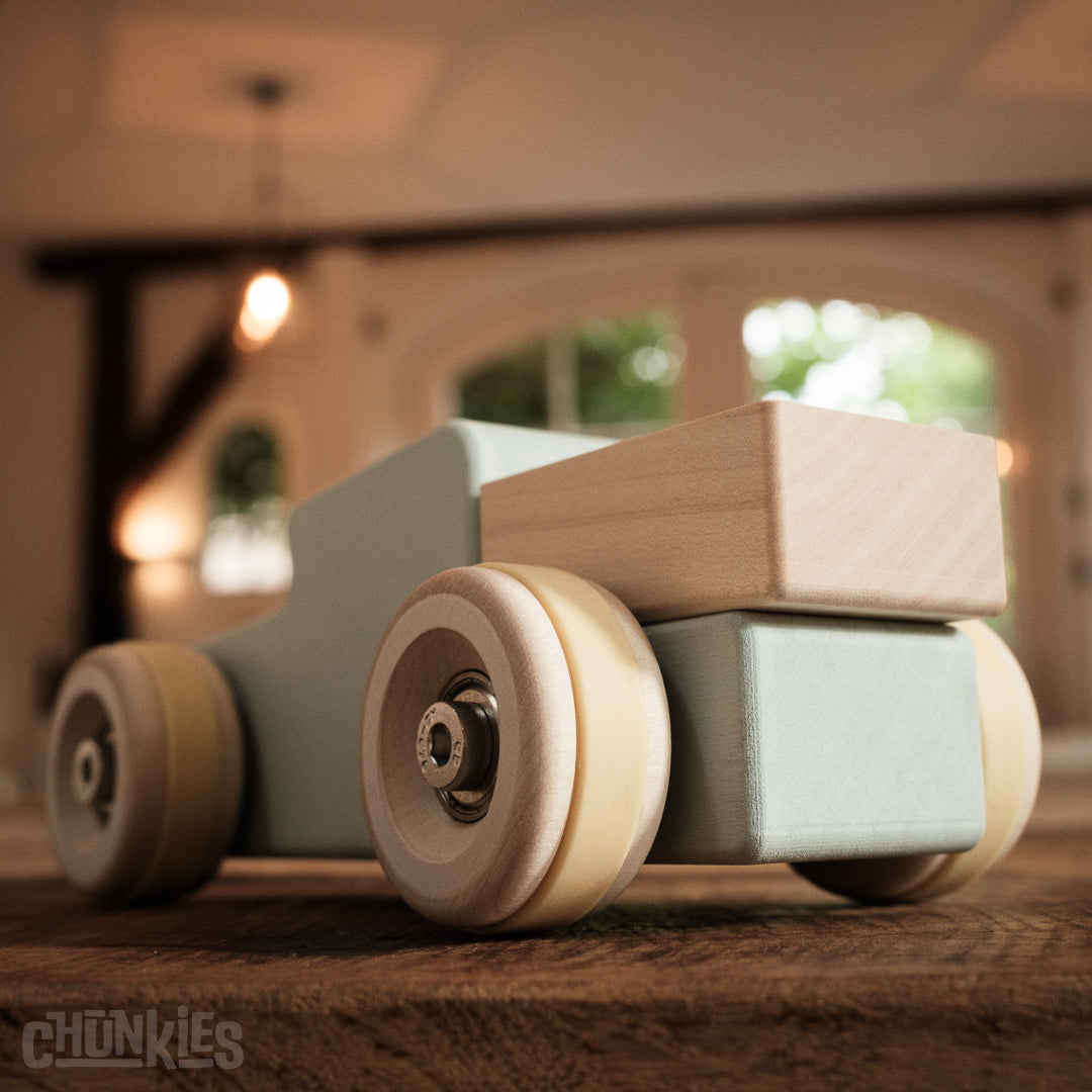 Close-up of the big wooden wheels and the loading bed of the Chunkies: Light blue wooden toy car in the shape of a vintage pick-up truck with wooden wheels, skate bearings and stainless steel hardware. Built to last generations. 