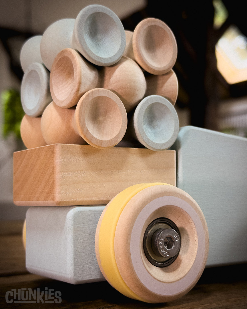 Chunkies: Light blue wooden toy car in the shape of a vintage pick-up truck with wooden wheels, skate bearings and stainless steel hardware. In this picture its carrying a load of Chill Pepper Sweets stacking toys. 