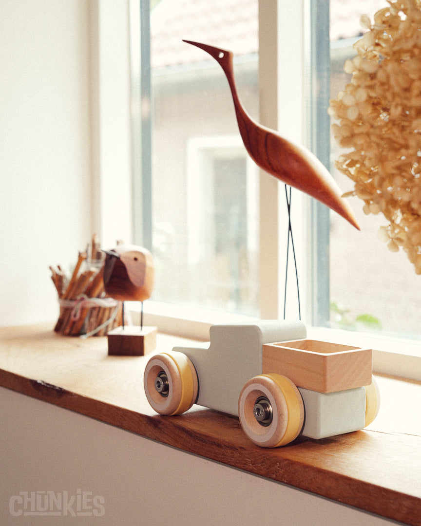 Wooden Chunkies toy truck on a windowsill with decorative items. Home in every interior. Made in Germany for kids and collectors