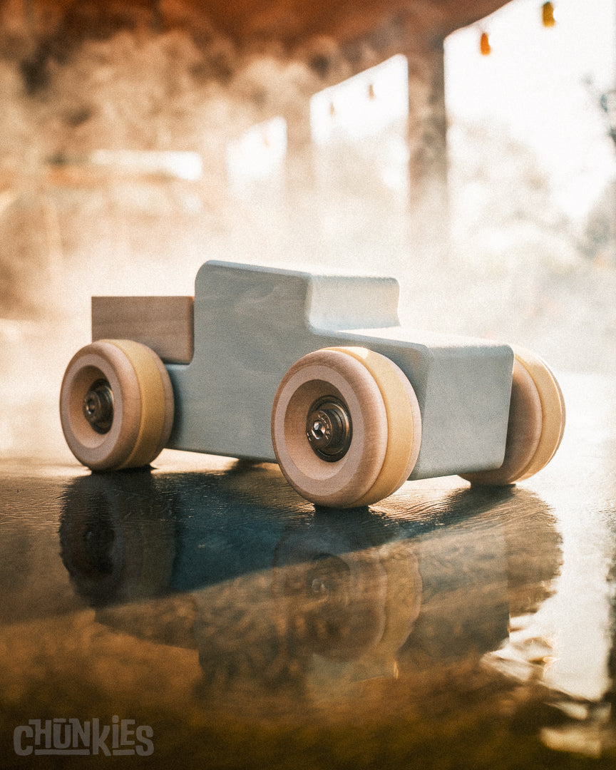 Chunkies No. 02 – Wooden Pick-Up Truck "The Workhorse" is a made in Europa solid wooden toy car / truck with big wooden wheels and worlds first real skate bearings for the smoothest ride. Never too old to play. Here the winter sun created a beautiful mist around this light blue car