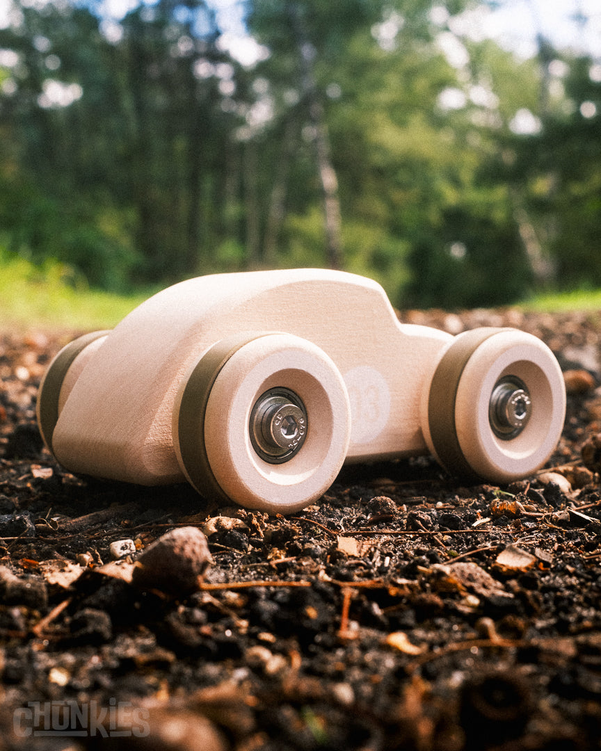 The cutest Chunkies wooden toy car shaped like a vintage Beetle in a forest environment. Child and planet safe