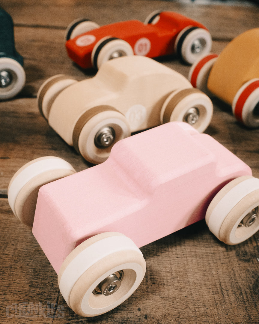 An overview of a couple of the Chunkies wooden toy car collection on a wooden table. 