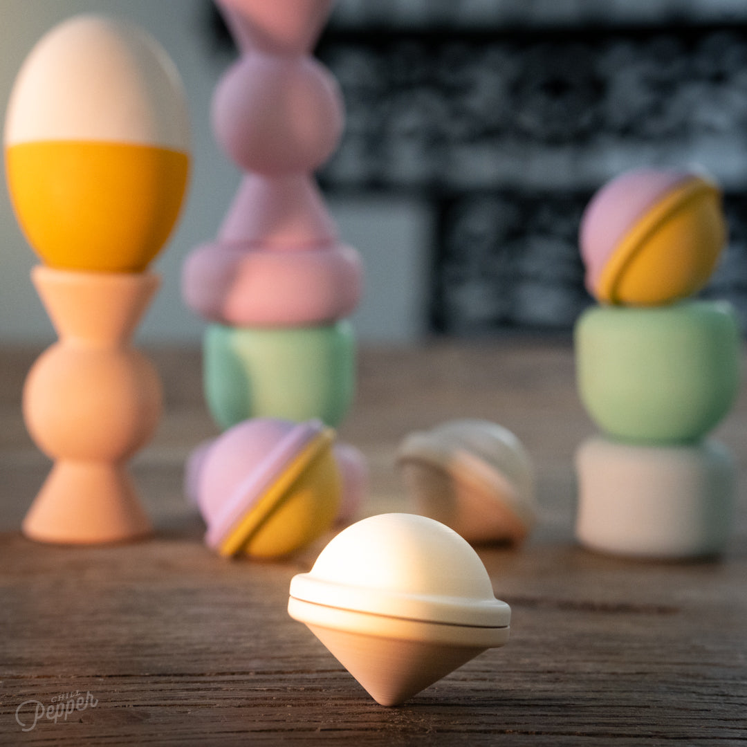 Wooden Chill Pepper Treats stacking and spinning game for ages 3 and up, made from eco-friendly maple wood and non-toxic, water-based paints. The set includes a variety of pastel-colored candy-shaped pieces and a unique Magic Egg for open-ended play.