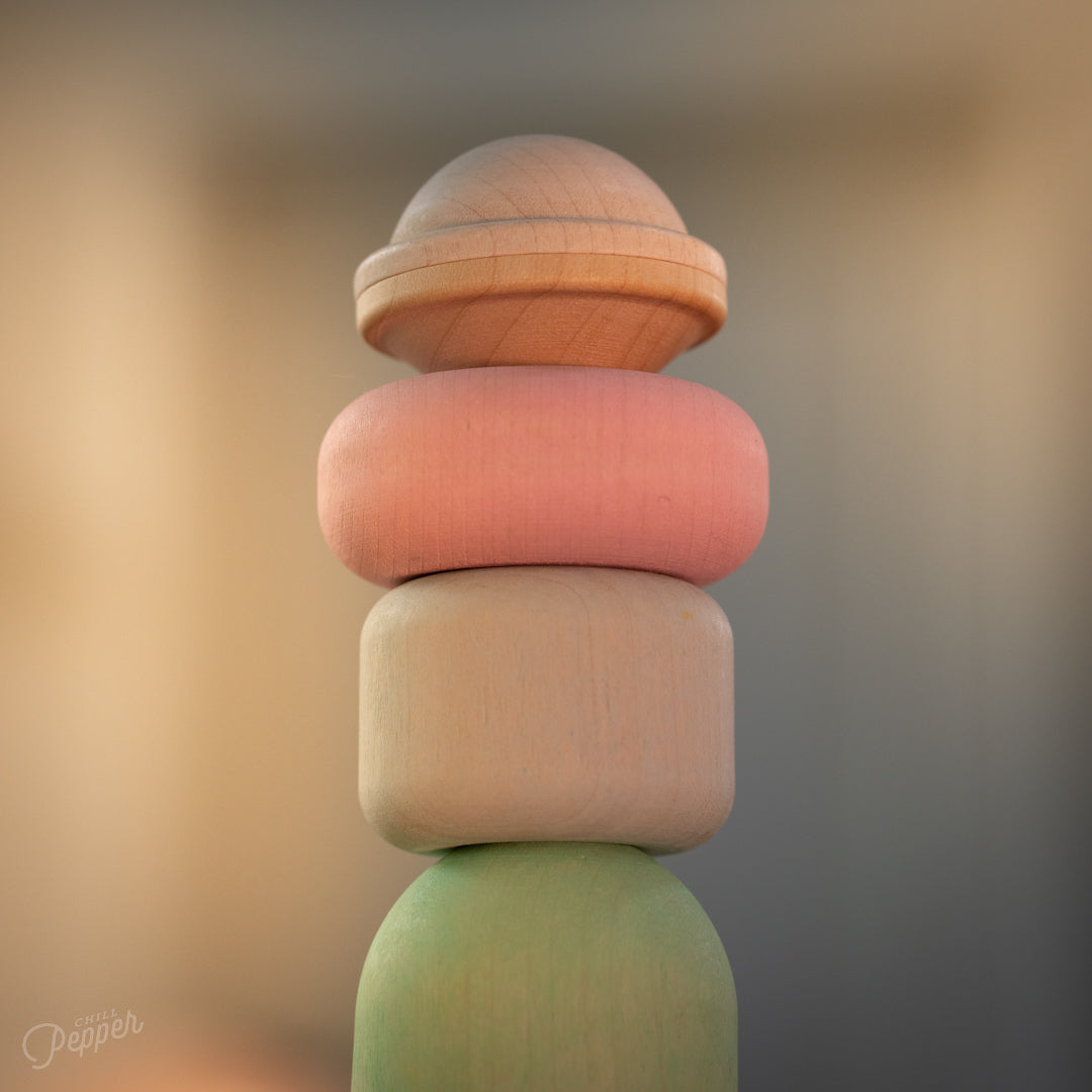 Wooden Chill Pepper Treats stacking and spinning game for ages 3 and up, made from eco-friendly maple wood and non-toxic, water-based paints. The set includes a variety of pastel-colored candy-shaped pieces and a unique Magic Egg for open-ended play.