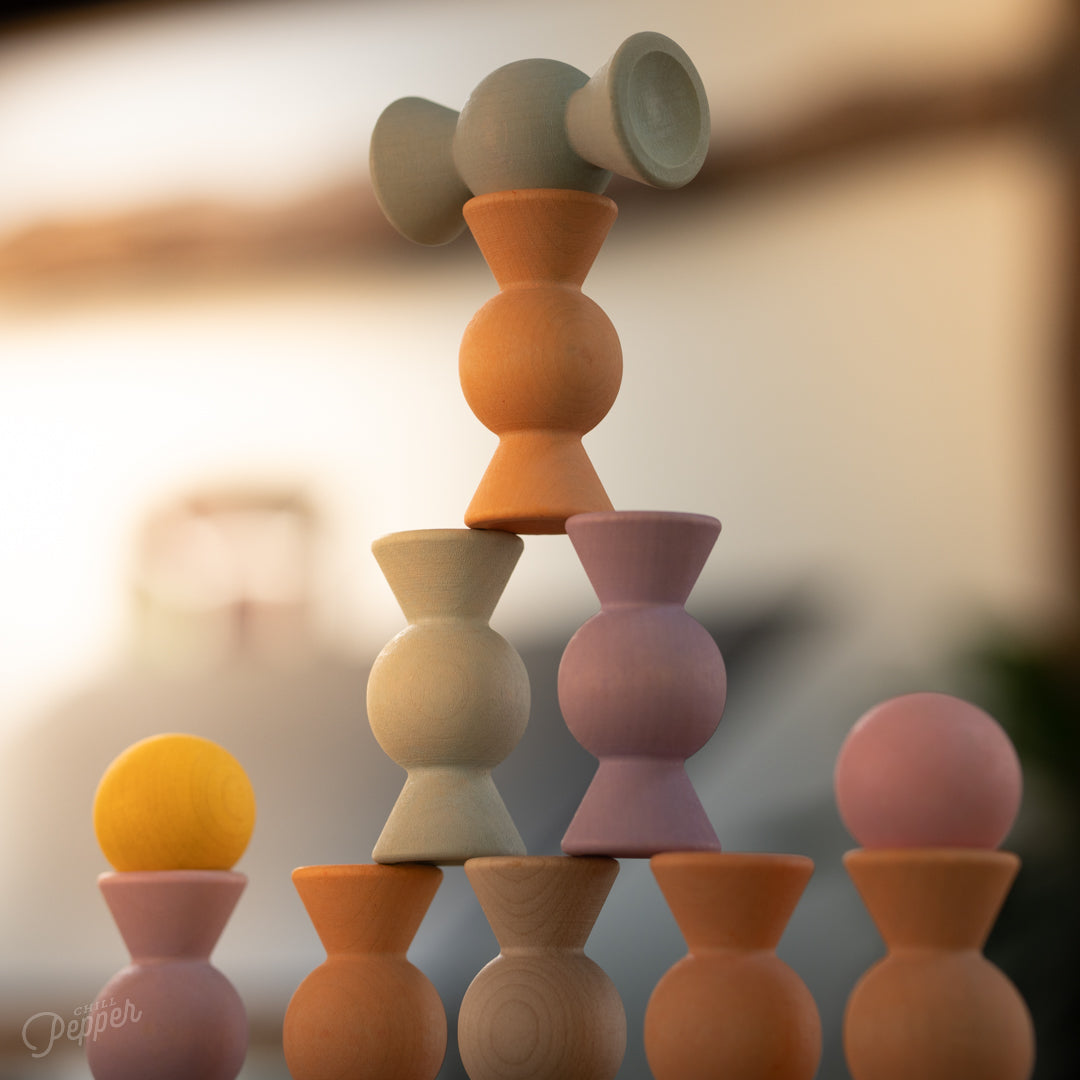 Wooden Chill Pepper Sweets stacking and spinning game for ages 3 and up, made from eco-friendly maple wood and non-toxic, water-based paints. The set includes 27 pastel-colored candy-shaped pieces and 6 gumballs for open-ended play.