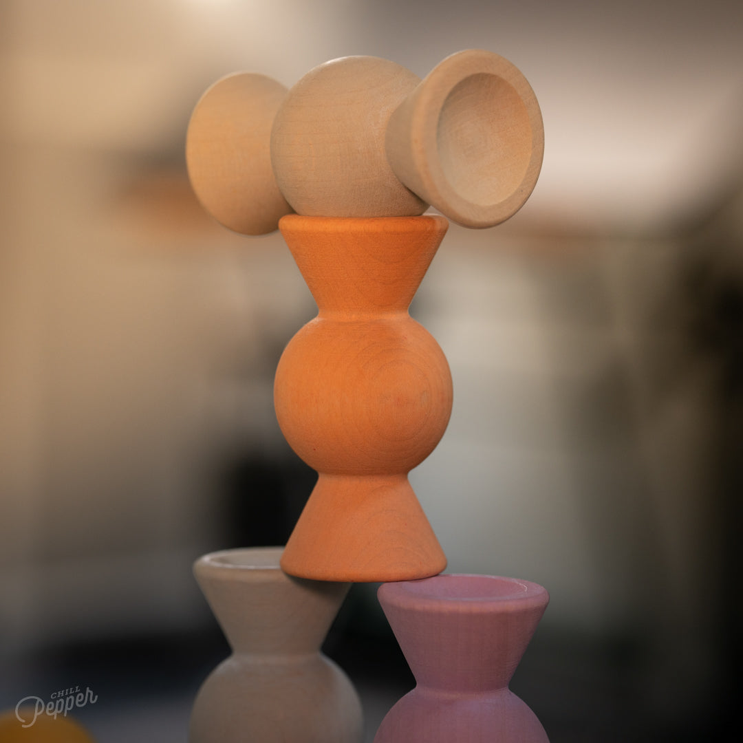 Wooden Chill Pepper Sweets stacking and spinning game for ages 3 and up, made from eco-friendly maple wood and non-toxic, water-based paints. The set includes 27 pastel-colored candy-shaped pieces and 6 gumballs for open-ended play.