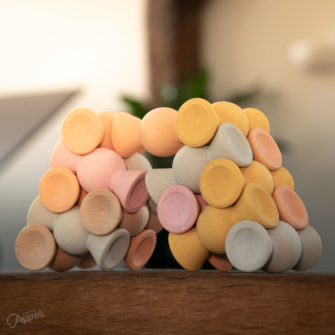 Wooden Chill Pepper Sweets stacking and spinning game for ages 3 and up, made from eco-friendly maple wood and non-toxic, water-based paints. The set includes 27 pastel-colored candy-shaped pieces and 6 gumballs for open-ended play.