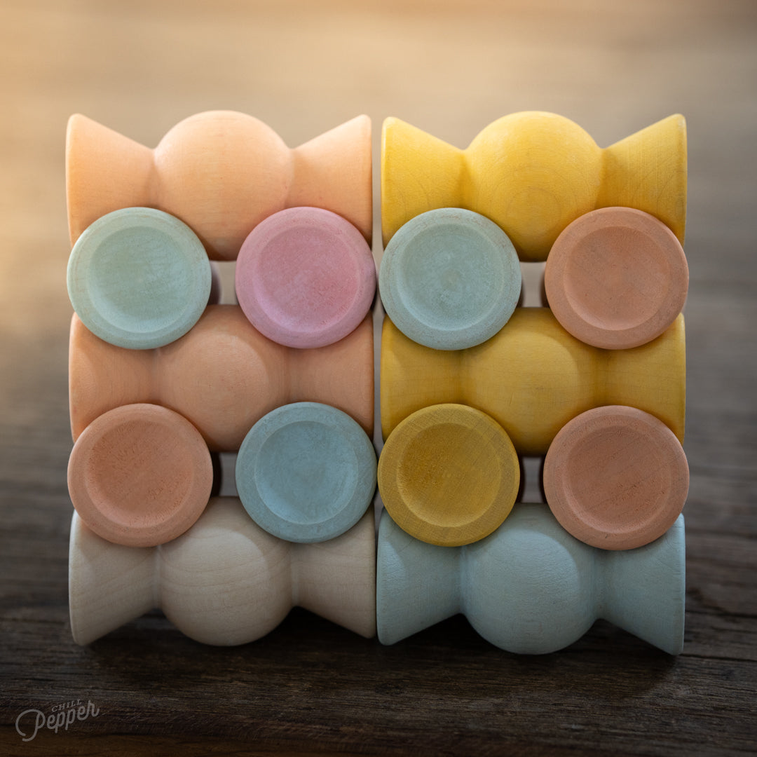 Wooden Chill Pepper Sweets stacking and spinning game for ages 3 and up, made from eco-friendly maple wood and non-toxic, water-based paints. The set includes 27 pastel-colored candy-shaped pieces and 6 gumballs for open-ended play.