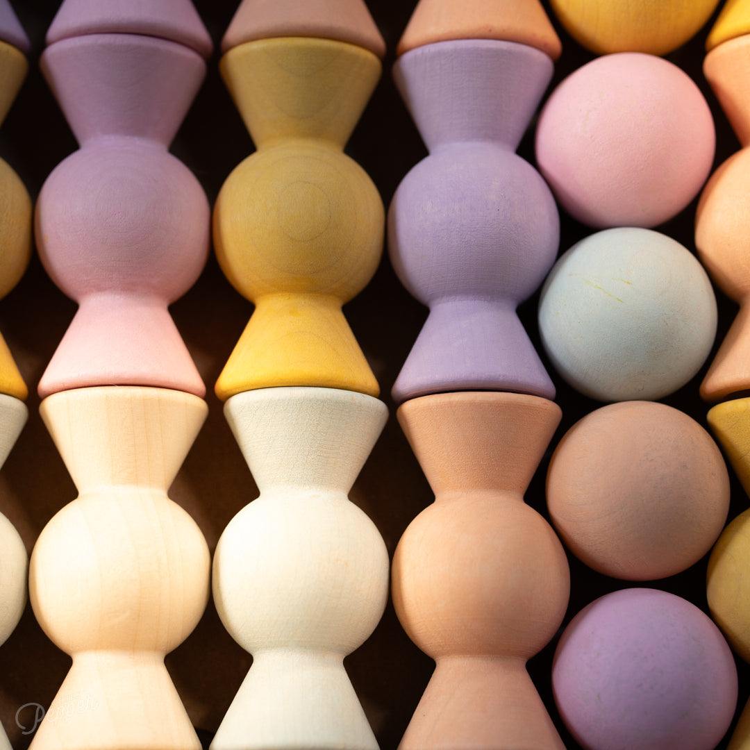Wooden Chill Pepper Sweets stacking and spinning game for ages 3 and up, made from eco-friendly maple wood and non-toxic, water-based paints. The set includes 27 pastel-colored candy-shaped pieces and 6 gumballs for open-ended play.
