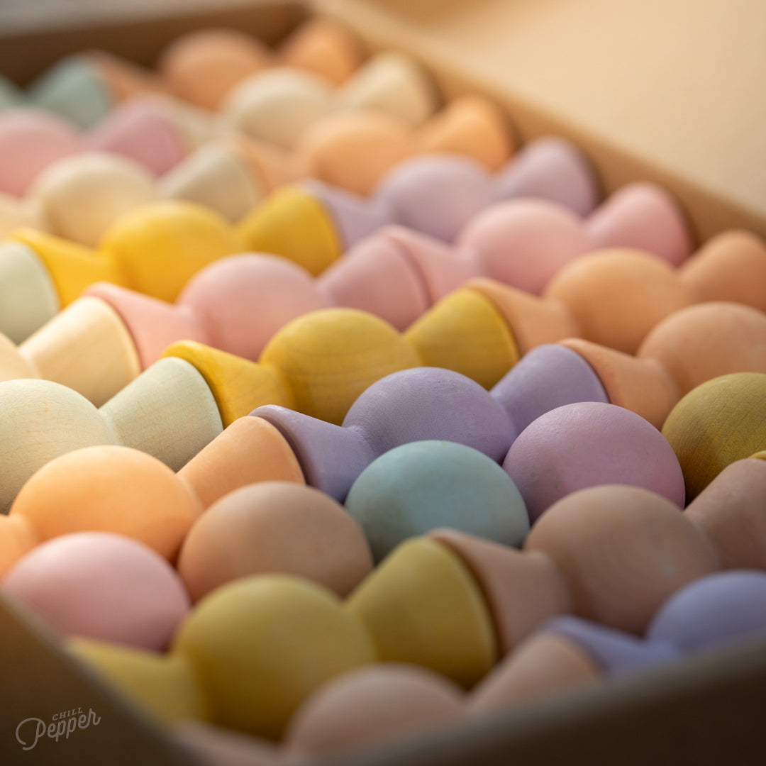 Wooden Chill Pepper Sweets stacking and spinning game for ages 3 and up, made from eco-friendly maple wood and non-toxic, water-based paints. The set includes 27 pastel-colored candy-shaped pieces and 6 gumballs for open-ended play.